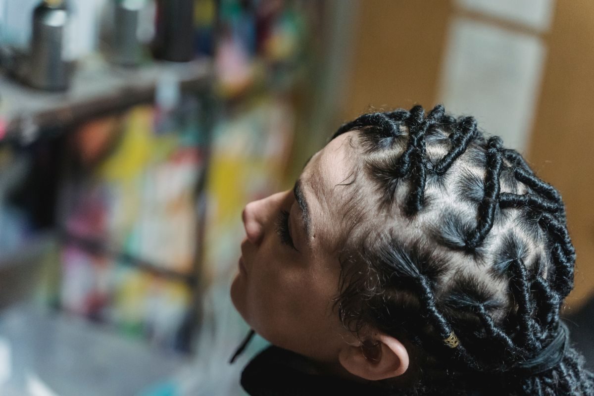 Tresses tirées près de la racine, illustrant la tension exercée sur la lisière du cuir chevelu.